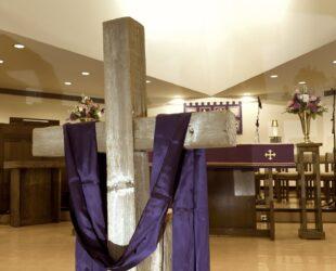a wood cross with a purple cloth hanging over it