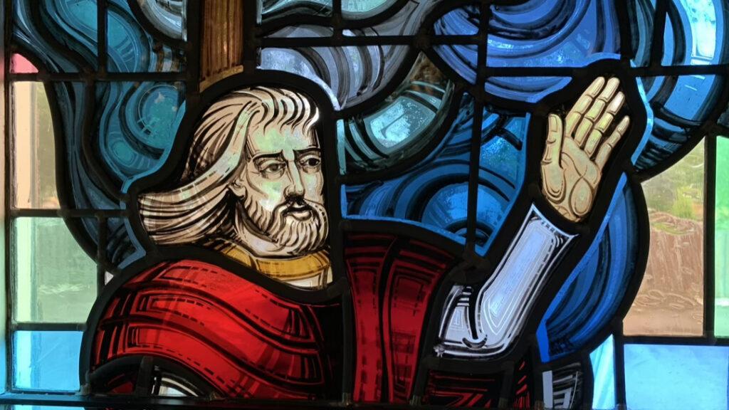 Stained Glass window of Jesus with his hand raised, calming the storm