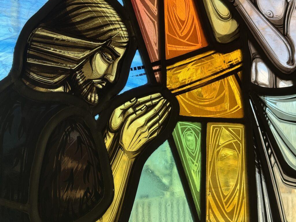 Stained Glass image of John The Baptist praying