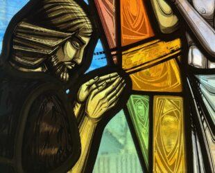 Stained Glass image of John The Baptist praying